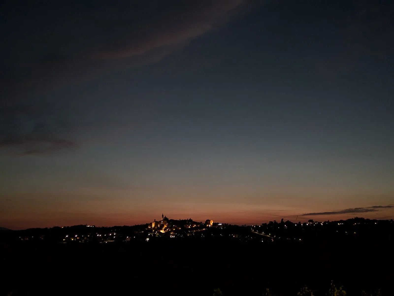 Il profilo di Corinaldo sulle colline dopo il tramonto